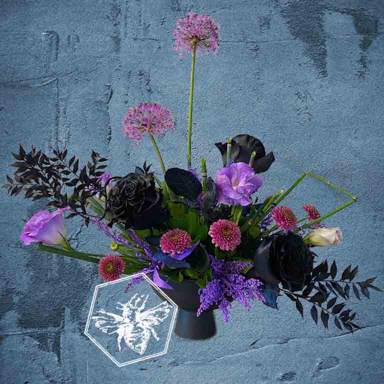 Modern seasonal flower arrangement with elevated feel and luxurious artisanal tone creatively and carefully crafted from the finest flowers and textures representing the season of the year featuring dyed black roses