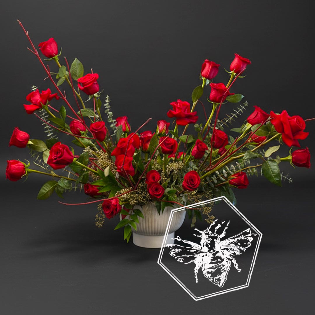 A modern arrangement of fresh cut roses with eucalyptus, Spanish moss, and complimentary greenery.