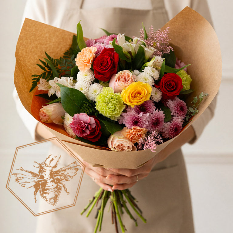 Huge bouquet of hand tied flowers featuring birds of paradise, toffee roses white roses, hydrangea and complimentary greenery
