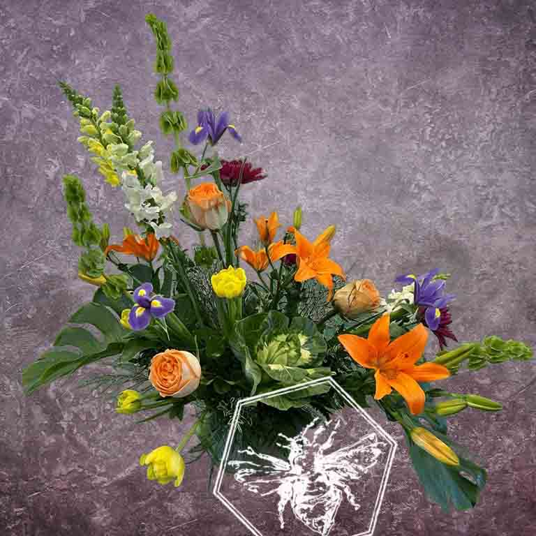 Large modern memorial flower arrangement and focal piece for service tables or church fronts, featuring a personalized, premium mix of colorful and white blossoms.