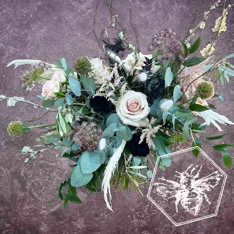 Large modern memorial flower arrangement and focal piece for service tables or church fronts, featuring a personalized, premium mix of colorful and white blossoms.