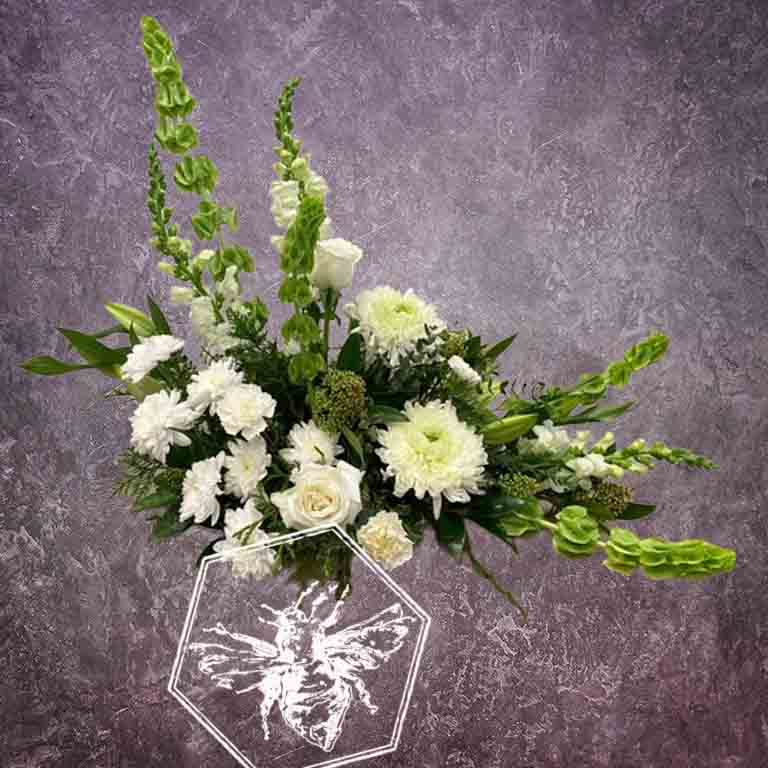 Large modern memorial flower arrangement and focal piece for service tables or church fronts, featuring a personalized, premium mix of colorful and white blossoms.