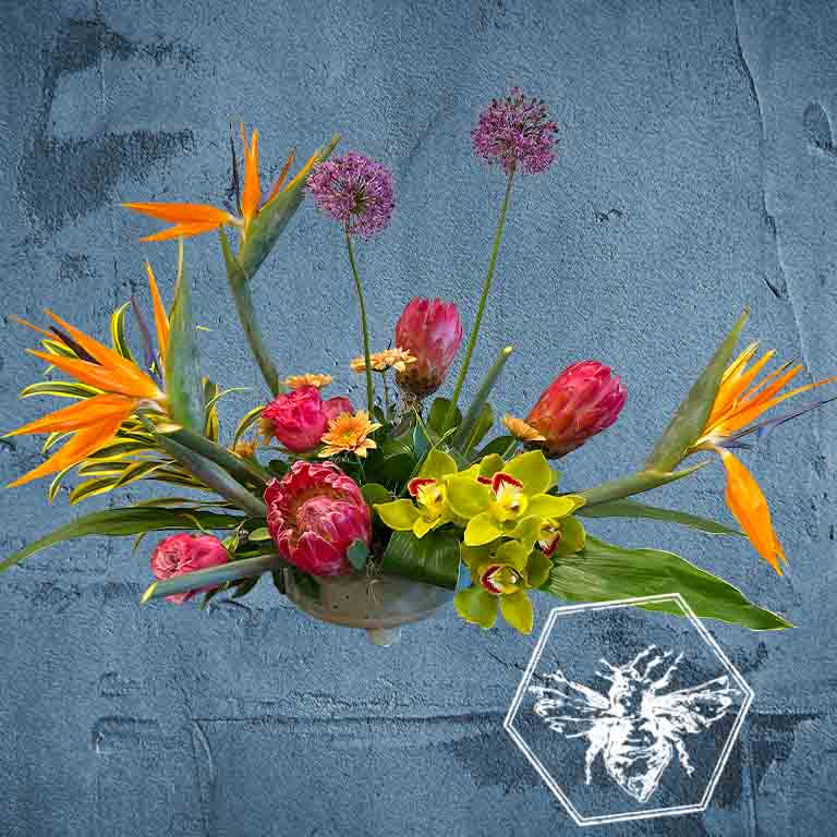 Creative fresh modern arranged tropical birds of paradise arranged with an assortment of complimentary flowers with greens and beautiful elevated accents