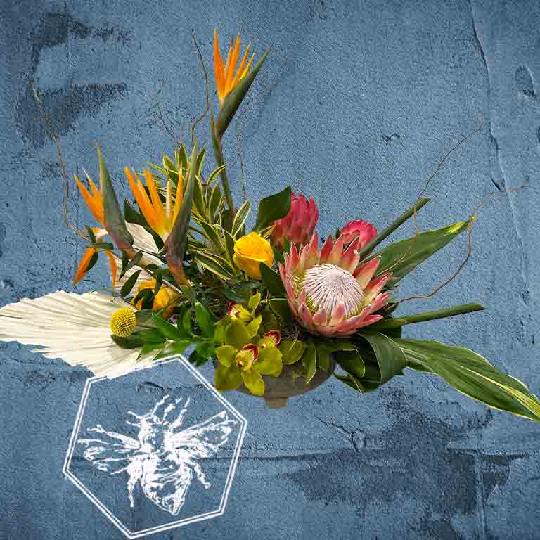 Creative fresh modern arranged tropical birds of paradise arranged with an assortment of complimentary flowers with greens and beautiful elevated accents