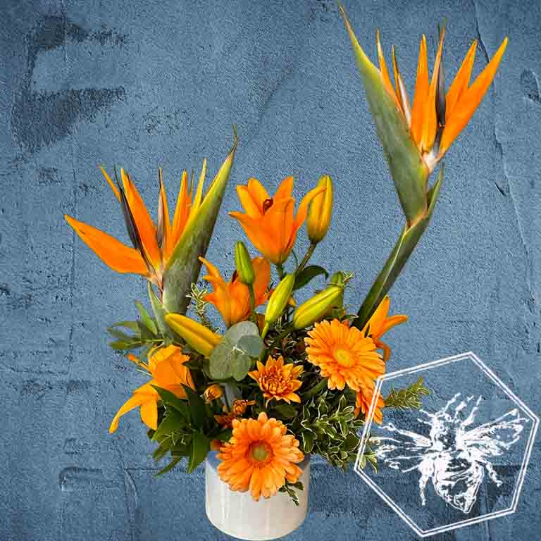 Creative fresh modern arranged tropical birds of paradise arranged with an assortment of complimentary flowers with greens and beautiful elevated accents