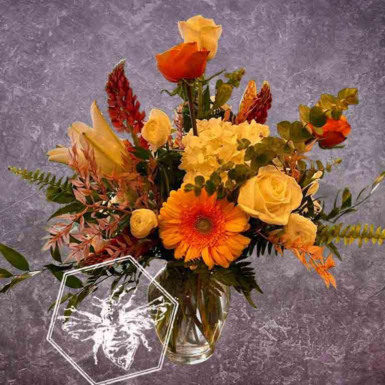 A bold, generous mix of vivid fresh flowers in a classic clear vase featuring hydrangea, roses, Gerber daisies and eucalyptus