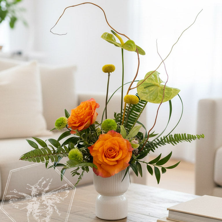 Floral arrangement with pink orchid, red roses, and greenery on a pink background with heart shapes.