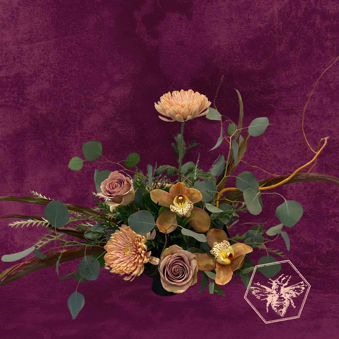 Modern seasonal flower arrangement with elevated feel and luxurious artisanal tone creatively and carefully crafted from the finest flowers and textures representing the season of the year featuring tan orchids and earth tomes