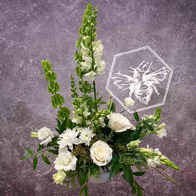 Large modern memorial flower arrangement and focal piece for service tables or church fronts, featuring a personalized, premium mix of colorful and white blossoms.