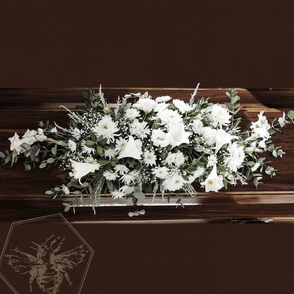 White flowers on a wooden casket with a dark background