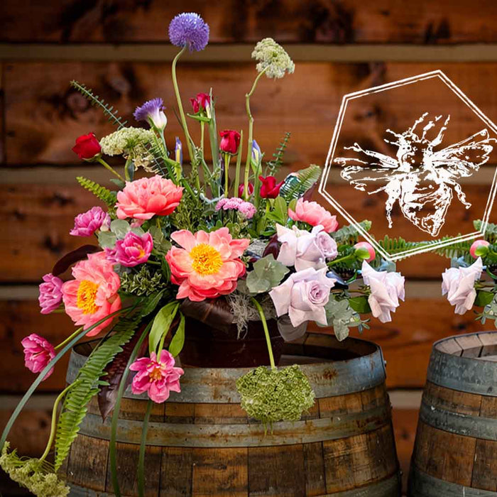 Event floral accent featuring peonies and roses on a wine barrel from The B Nest Studios