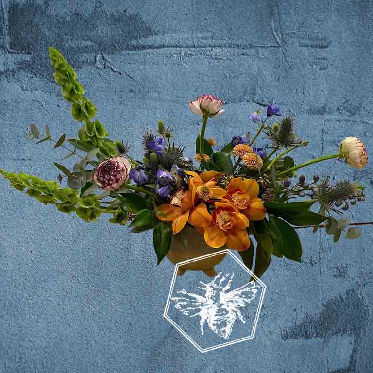 Modern seasonal flower arrangement with elevated feel and luxurious artisanal tone creatively and carefully crafted from the finest flowers and textures representing the season of the year featuring earth toned orchids