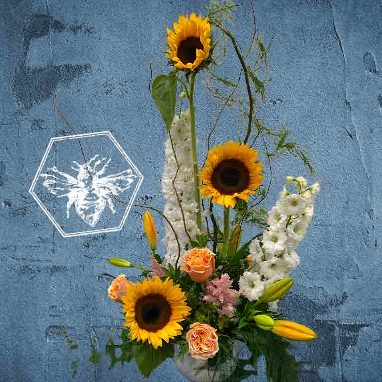 Modern seasonal flower arrangement with elevated feel and luxurious artisanal tone creatively and carefully crafted from the finest flowers and textures representing the season of the year featuring sunflowers and lilies
