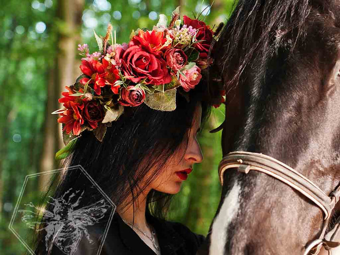Exquisite red floral crown on dark haired woman with a horse during an event