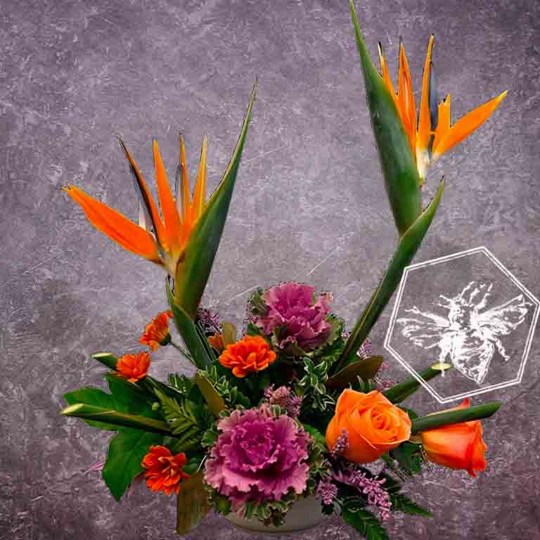 Creative fresh modern arranged tropical birds of paradise arranged with an assortment of complimentary flowers with greens and beautiful elevated accents