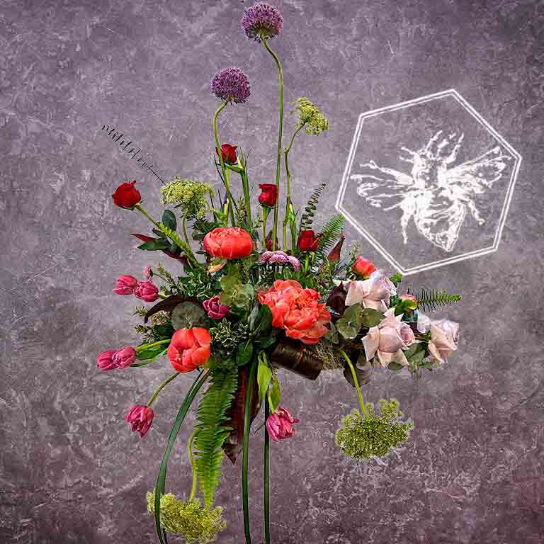 Large modern memorial flower arrangement and focal piece for service tables or church fronts, featuring a personalized, premium mix of colorful and white blossoms.