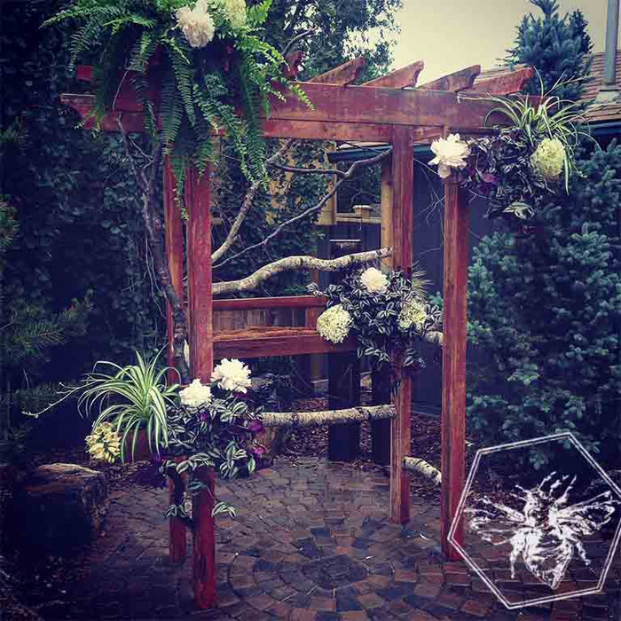 Gazebo for event featuring white peonies, ferns and birch poles