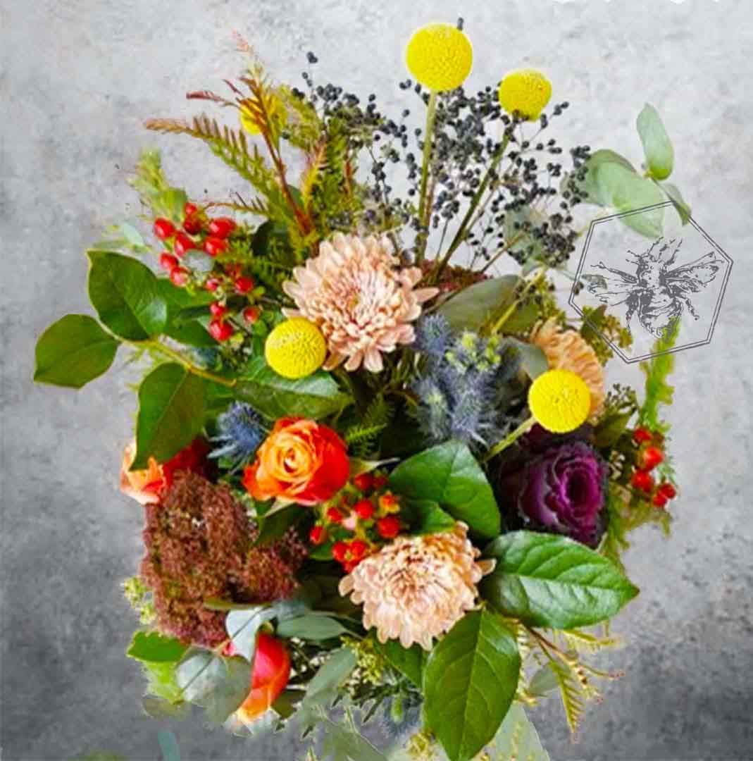 Colorful wildflower bouquet of flowers with greenery on a textured gray background