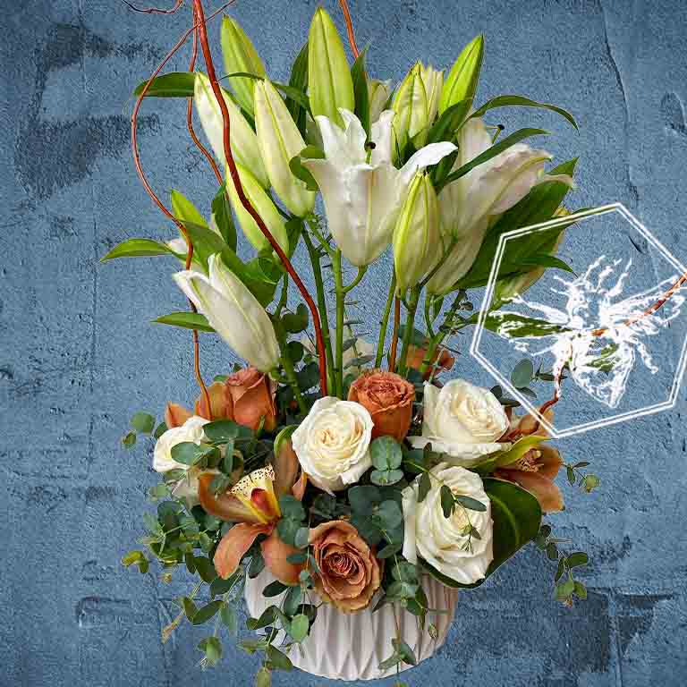 A modern, vertically styled sympathy floral arrangement in a neutral ceramic pot, featuring a lush mix of premium white and soft pastel blossoms accented with green foliage