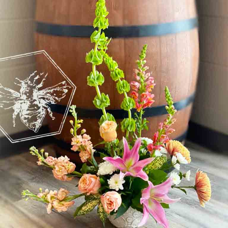 Large modern memorial flower arrangement and focal piece for service tables or church fronts, featuring a personalized, premium mix of colorful and white blossoms.