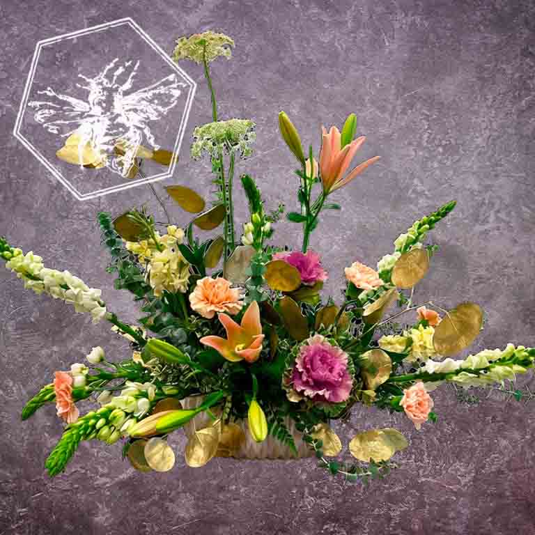 Large modern memorial flower arrangement and focal piece for service tables or church fronts, featuring a personalized, premium mix of colorful and white blossoms.