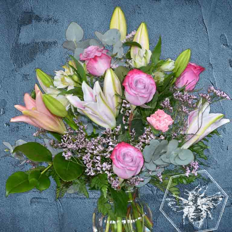 Premium fresh roses and luxurious lilies with complimentary florals elegantly arranged 