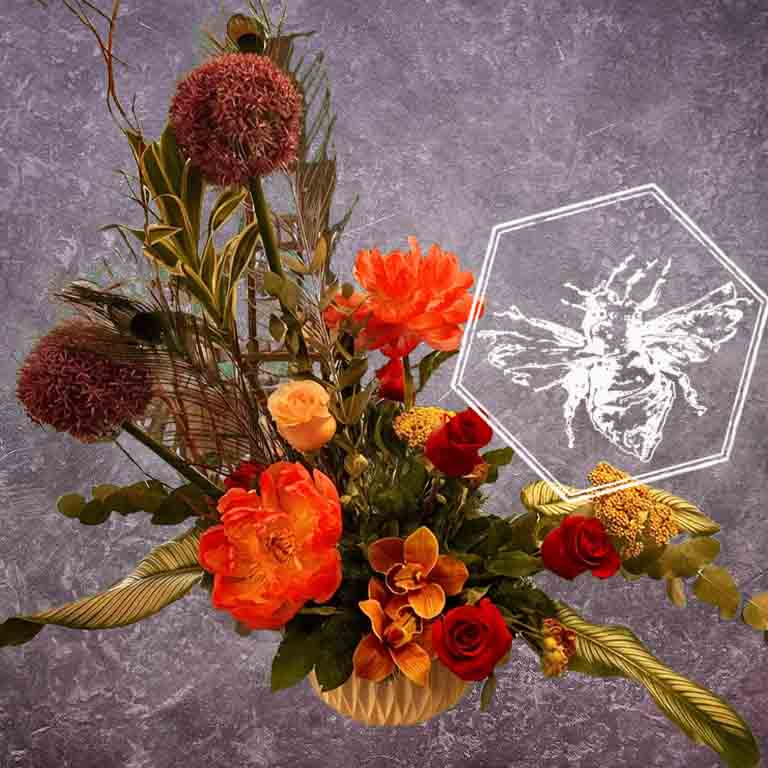 Modern seasonal flower arrangement with elevated feel and luxurious artisanal tone creatively and carefully crafted from the finest flowers and textures representing the season of the year featuring roses, allium, peonies, orchids and variegated greenery 