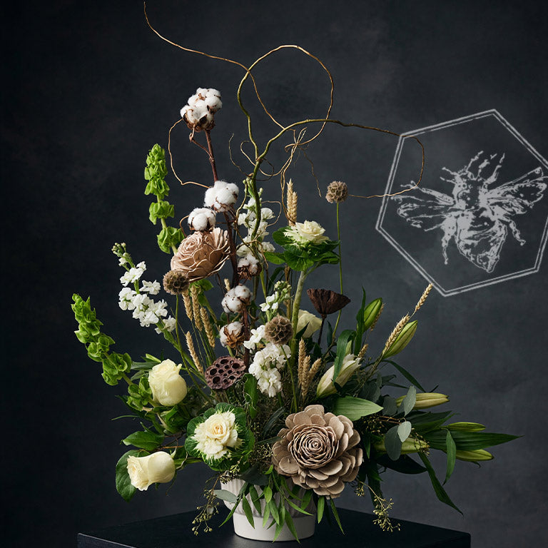 Large memorial accent florals featuring bells of Ireland, white roses, lilies, dried cotton and wheat.