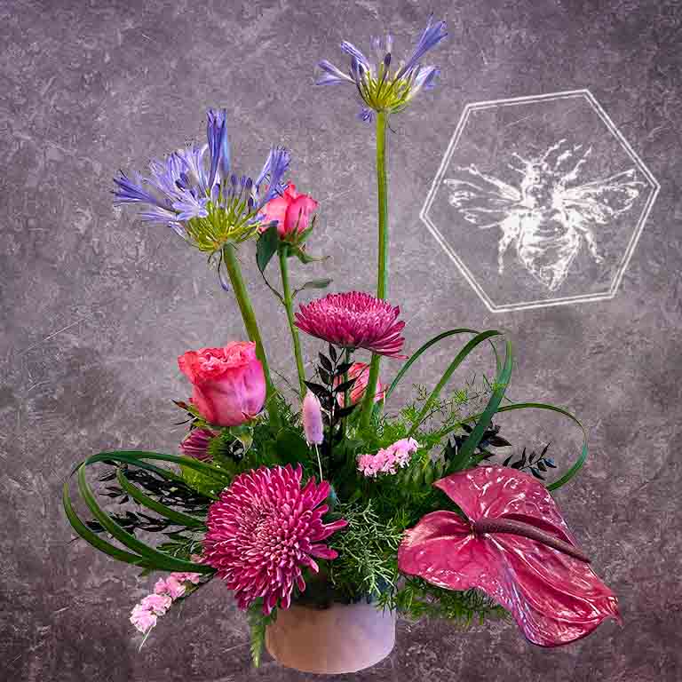 Modern floral arrangement with pink and purple flowers on a gray background