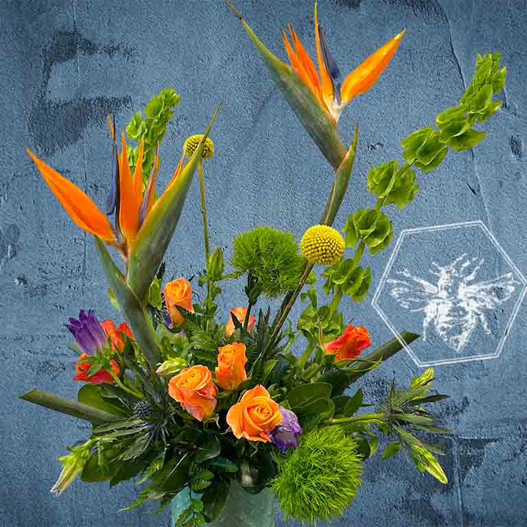 Creative fresh modern arranged tropical birds of paradise arranged with an assortment of complimentary flowers with greens and beautiful elevated accents