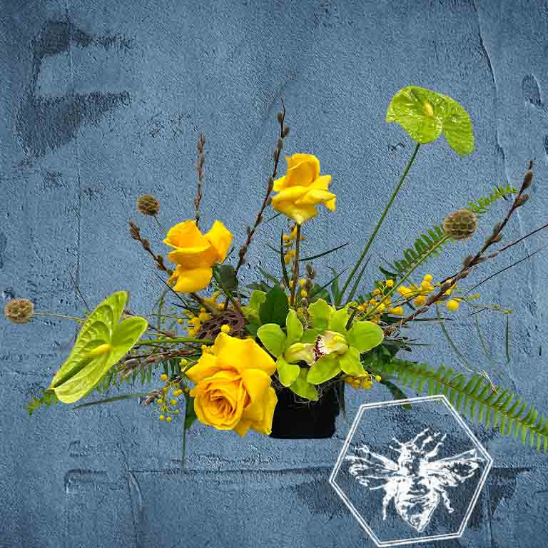 Modern seasonal flower arrangement with elevated feel and luxurious artisanal tone creatively and carefully crafted from the finest flowers and textures representing the season of the year featuring reflexed yellow roses, green giant cymbidium orchids, pussy willows and green anthurium