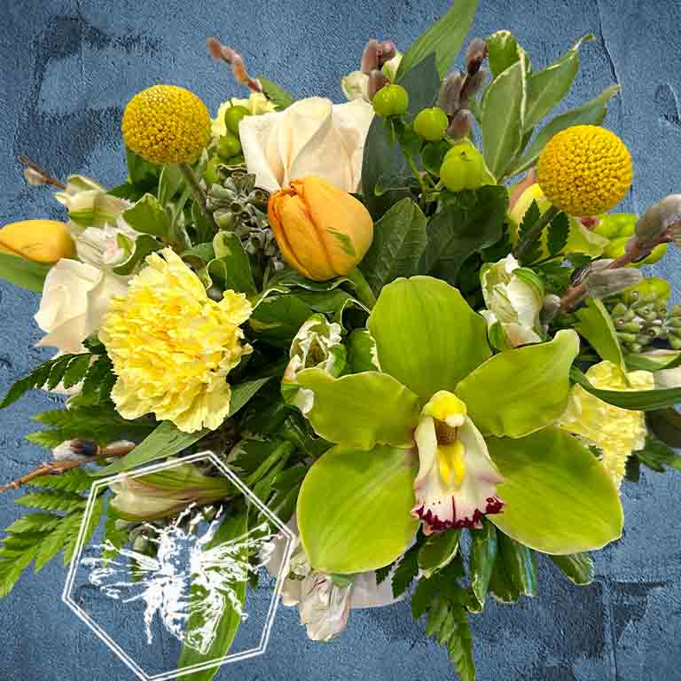 Bouquet of flowers with green orchids, yellow carnations, and other greenery on a textured blue background.