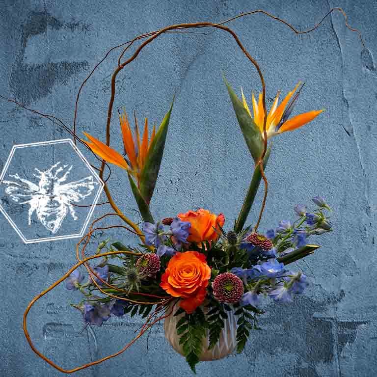Creative fresh modern arranged tropical birds of paradise arranged with an assortment of complimentary flowers with greens and beautiful elevated accents