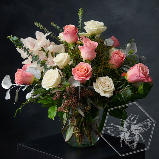 Black roses in a vase with a red heart-shaped watercolor design on a gray background.